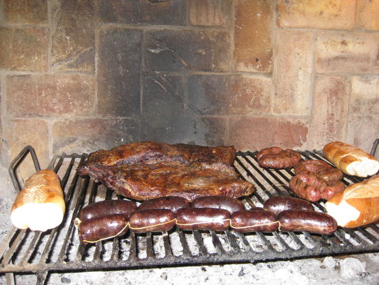 Das Asado - vorne die Blutwuerste, recht Chorizos und dahinter zwei saftige Stuecken Rindfleisch.