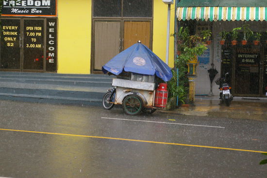 Selbst die Strassenverkaeufer haben bei diesem Regen keine Lust zum Arbeiten.