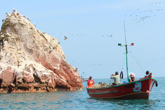 Hinter den Felsen suchen die Fischerboote ihr Glück