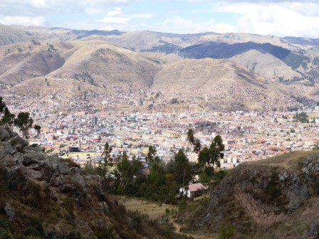 Aussicht auf Cusco, das in einem Kessel liegt mit überbauten Hügeln auf allen Seiten.