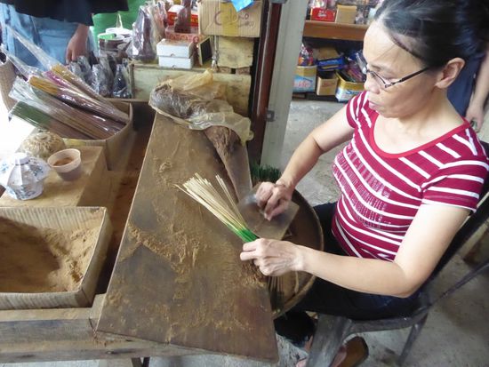 Zimtpaste wird durch Rollen an die Stäbchen geheftet