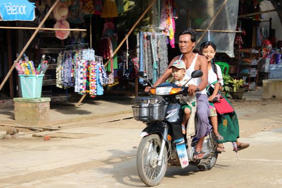 Auch wenn man es nur anhand der Beine sieht, hier sitzen vier Personen auf dem Motorrad - und das Mädchen hinten sitzt ausserdem seitlich darauf.