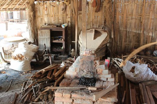 die Esse mit dem grossen Blasbalg, der mit der Schnur im Vordergrund bedient wird.