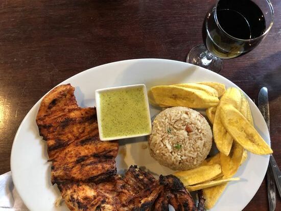 Hühnchen vom Grill mit scharfer Sosse, dazu gebratenen Reis und fritierte Platanos