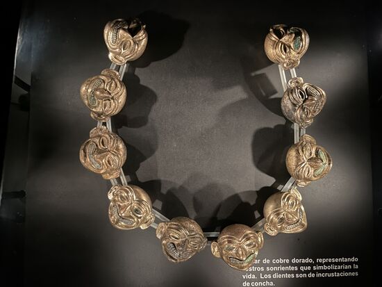 Eine Halskette aus lächelnden Masken als Symbol für das Leben