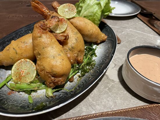 Mein Nachtessen aus frittierten mit Teig ummantelten Crevetten schmeckt wunderbar. Das Glas Weisswein muss warten bis ich wieder zu Hause bin.