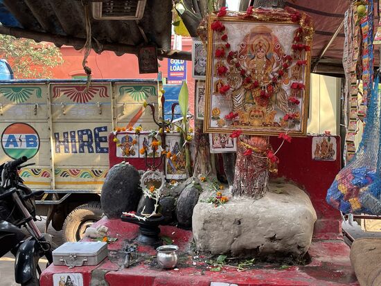 Eine kleine Gebetsstätte bei einem Baum mitten im Chaos der Stadt.