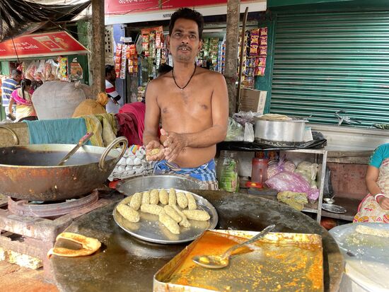 Er macht Fischkroketten, paniert sie und frittiert sie im heissen Oel