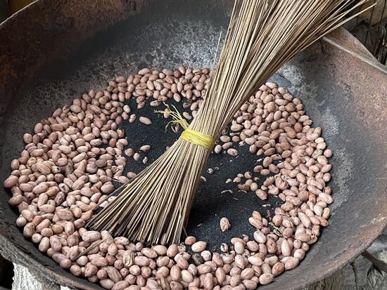 Frisch geröstete geschälte Erdnüsse. Geröstet werden sie mit schwarzem Sand, der vor dem Verkauf abgesiebt wird.
