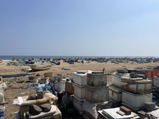 Hinter den Verkaufsständen liegen die Fischerboote am Strand