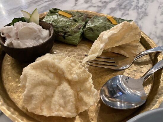 Fisch in Tomaten-Chili-Kokosnuss-Sauce, eingepackt im Bananenblatt