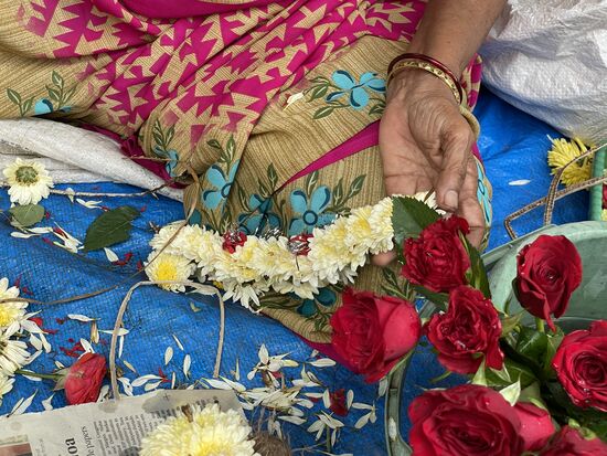 Vor dem Tempel werden Blumenkränze gemacht und verkauft.
