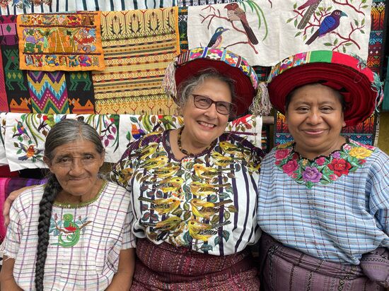 Juana (rechts) zeigt den Touristen wie man den Tocoycal richtig bindet.