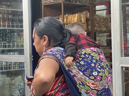 Ein eher seltenes Bild, eine Mutter mit ihrem Kind auf dem Rücken.