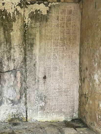 eine Steintafel mit Inschriften in dem Raum oben am Ende der Treppe.