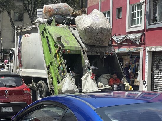 Da hockt einer hinten im Abfallwagen...
