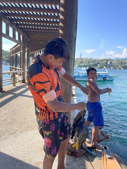 Ein guter Fang hat der Junge gemacht. Mit einer einfachen Fischerrute direkt am Quai