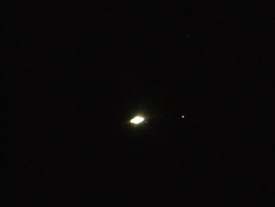 Die zwei weissen Punkte rechts von Saturn sind zwei seiner 60 Monde