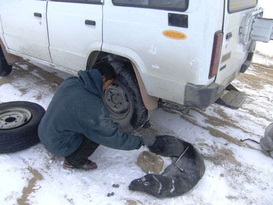Fred leiht Stanzin, unserem Driver, seine Handschuhe, damit er sich die Finger nicht abfriert beim Reifenwechsel