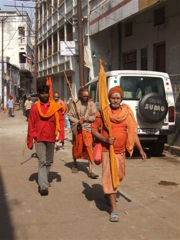 Maenner pilgern von ihrem Tempel zum Ganges, um sich dort zu waschen