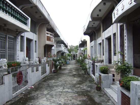 Das ist eine Strasse im Friedhof, anstatt Grab neben Grab steht hier eben ein Haus (mit Balkon!) neben dem anderen