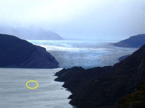 ...der schwarze Punkt im Kreis ist eines der Ausflugsboote zum Gletscher und hat Platz fuer geschaetzte 15 Personen. Der Gletscher im Hintergrund ist der rechteste Auslaeufer des Grey.....