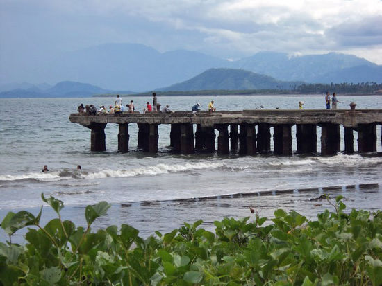 Bei als kühl empfundenem Wetter genießen Einheimische das Meer von diesem Steg aus