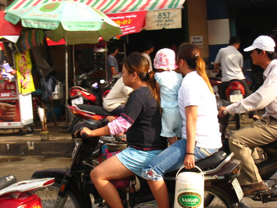 Auf den Strassen Saigons (fliessender Verkehr!) Der Kleine fährt im Stehen mit.