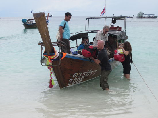 das Longtail Boat fuer THB50, nasse Fuesse/Hose inklusive, rechts im Hintergrund die Plattform, wo das Speed Boat gehalten hat