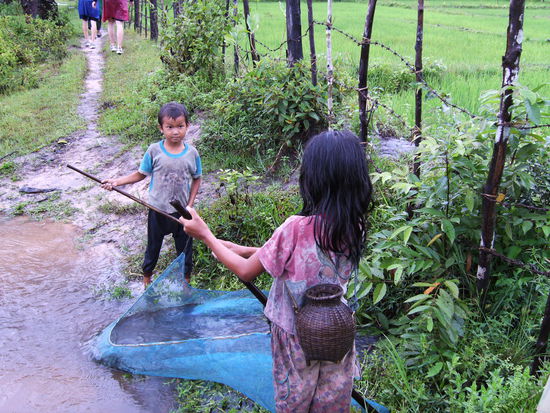 Kinder beim Fischfang. Im kleinen Beutel hinten sind kleine Fische