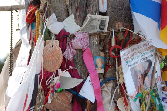 Pilgerwuensche am Cruz de Ferro - neben Schutt auch Votivgaben, durchlaufene Schuhe und platte Radreifen