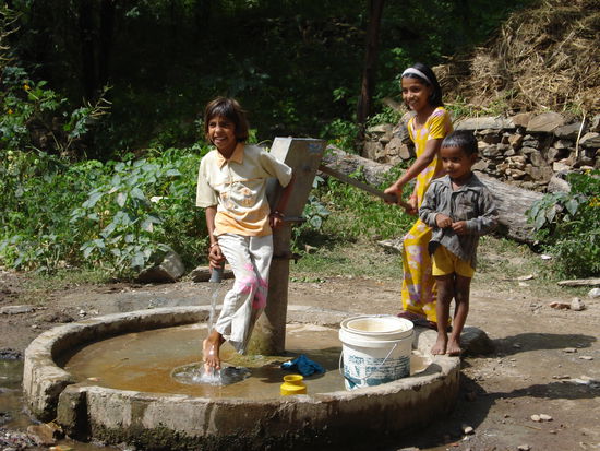 Kinder beim Dorfbrunnen