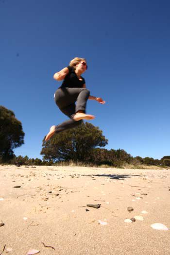 Anne jumping on a beach