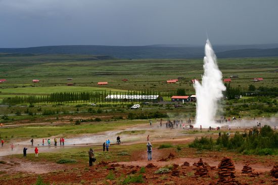 Strokkur mit vielen Touristen im Regen