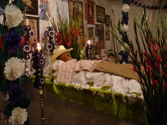 ein Totenkopf (z.B. aus Zucker) wird oben auf dem Altar deponiert und neue Kleider für den Verstorbenen bereitgelegt