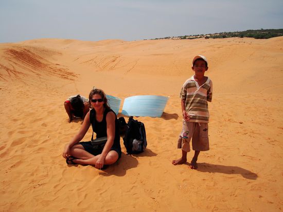 Dane auf der roten Sandduene mit dem jungen Duenen-Board-Verkaeufer.