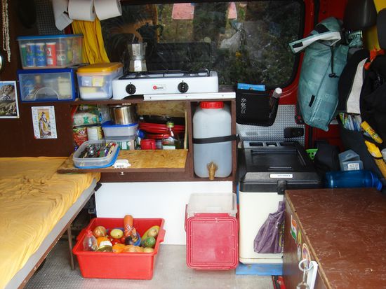 ...weisser 2 Flammengasgrill mit Espresso-Maschine, offenem Kuechenschrank, Tank mit "Lavabo", rechts im schönen kakao-braun die Sitzbank (Werkzeugbehälter), hinten rechts unser Kühlschrank