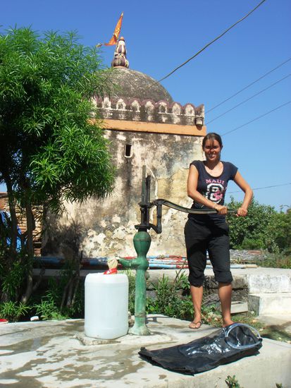 Lucy am Wasserpumpen vor einem hinduistischen Tempel auf der Insel Diu in Indien