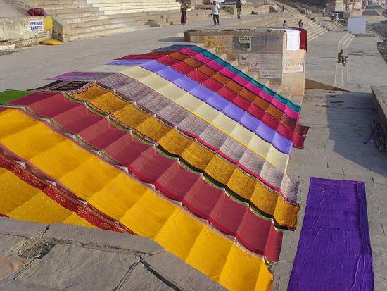 Die Saris trocknen nach der Waesche in der Sonne auf den Stufen des Ganges - ein Farbenspiel!!