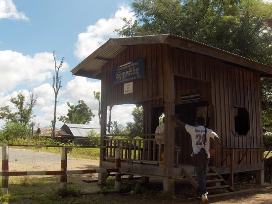 Ein besserer Holzverschlag stellte das kambodschanische Immigration Office dar. Zusaetzlich zum 20-Dollar-Visum musste man fuer jeden der 3 benoetigten Stempel noch einen zusaetzlichen Dollar “rueberschieben”… Kein Wunder das Kambodscha unter einer enorm hohen Korruption leidet. Weniger Erfolg hatten die 2 Afro-Amerikaner, die aus welchem Grund auch immer (leider vermutlich wegen der Hautfarbe) jeweils 50 Dollar extra haetten bezahlen sollen, obwohl sie sogar im voraus schon ihr Visum organisiert hatten. Zurecht weigerten sich die beiden dieses hohe "Schmiergeld" zu bezahlen, wurden dann allerdings von den unfreundlichen Grenzbeamten wieder weggescheucht. Die armen Jungs mussten dann den 7 km langen Schlammweg bis zur laotischen Grenze zurueck laufen. Echt eine Schweinerei!