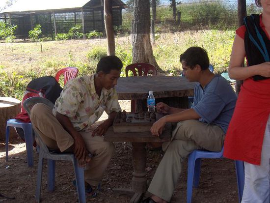 Nachdem jeder unserer Gruppe sein Visum und die noetigen Stempel hatte, mussten wir trotzdem erneut warten… unser Fahrer (links im Bild) musste erst noch sein Schachspiel zu Ende bringen…