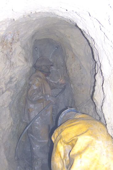 Die Minenarbeiter fuellen Dynamit in die Bohrloecher.