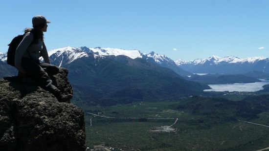 Anita geniesst die Sicht auf die umliegenden Berge und den See.