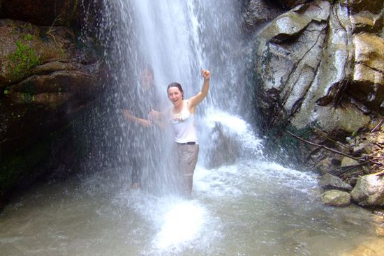 Anita springt sogar mitsamt den Kleidern unter den Wasserfall