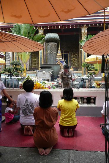 Die Leute bringen Opfergaben und beten in den Tempeln oder vor Buddhastatuen.