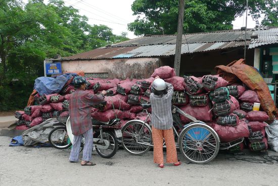 Hier werden sackweise Kohle auf Fahrräder geladen.