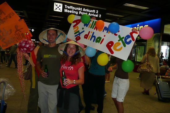 DIE ÜBERRASCHUNG!! In Zürich Flughafen werden wir von Freunden mit Plakaten, Gejubel und Schweizer Bier empfangen.