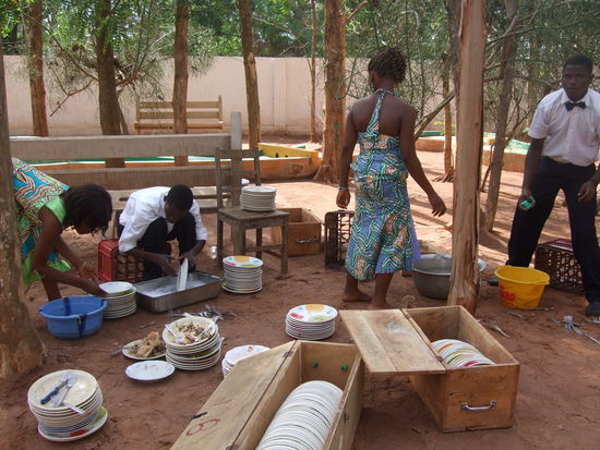 Mireille und Tata Vivi beim Spülen mit den Kellnern (auch sie tragen den Stoff)