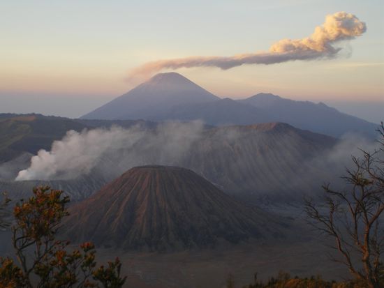 Der Mount Bromo ist der kleinste der drei Vulkane (links). Dahinter Javas groesster Berg, der Mt. Semeru (3676 Meter hoch), der etwa alle 20 Minuten Rauch ausstoesst!