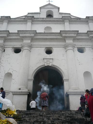 Ein Schamane vor der katholischen Kirche, erbaut auf den Grundmauern und Stufen des alten Mayatempels